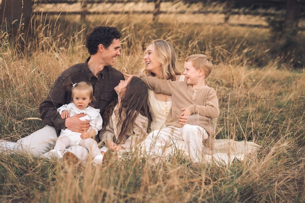 A family laughing together in golden fields
